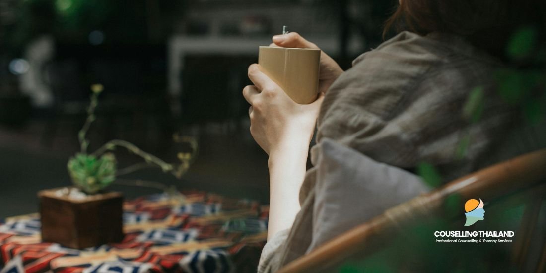 ผู้หญิงนั่งจิบชาในบ้าน